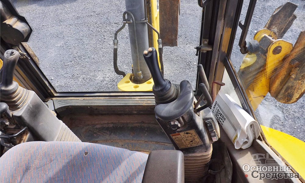 Управление экскаватором-погрузчиком New Holland B115.B осуществляется с помощью джойстиков и кнопок
