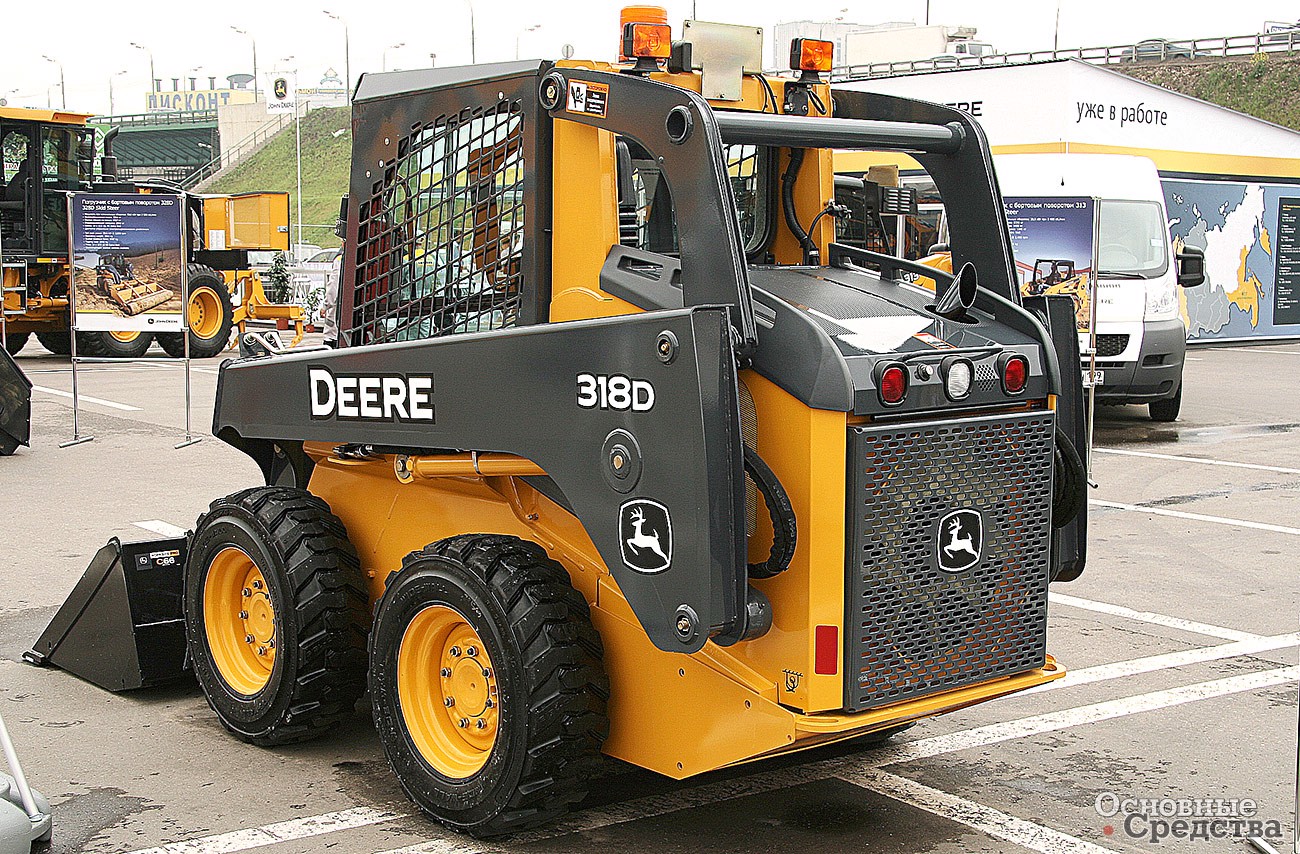 John Deere 318D. Обратите внимание на механизм подъема стрелы