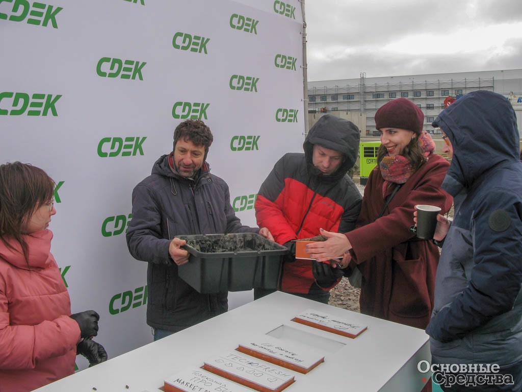 Журналисты закладывают первые камни в основание нового склада